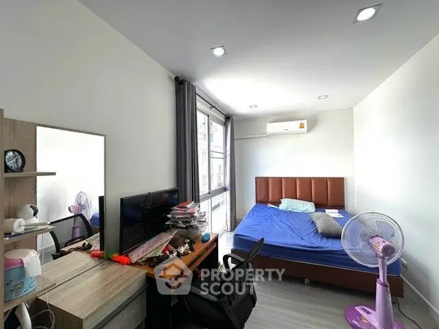 Modern bedroom with desk and large window in a stylish apartment.