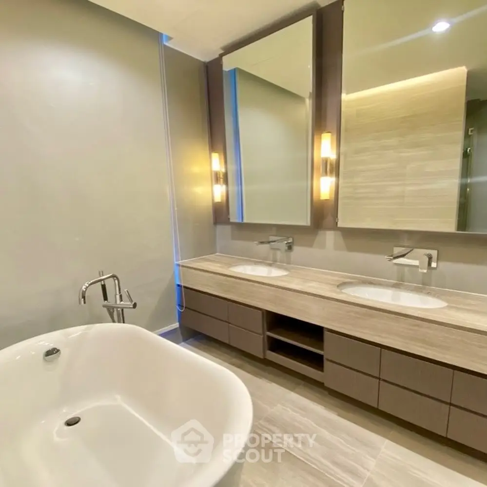 Luxurious modern bathroom with dual sinks and elegant bathtub.