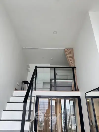 Modern loft apartment with high ceilings and large windows offering city views.