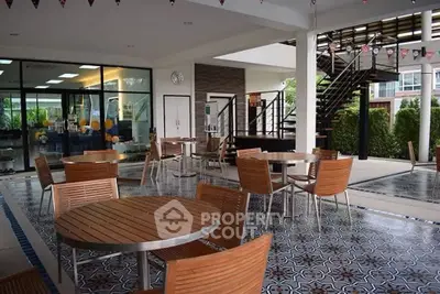 Stylish outdoor common area with modern seating and decorative flooring in a residential complex.