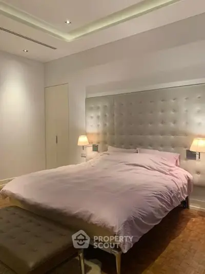 Luxurious bedroom with elegant lighting and plush headboard, perfect for relaxation and comfort.