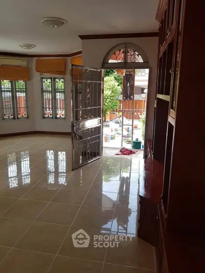 Spacious living room with tiled floor and large windows, offering a bright and airy atmosphere.