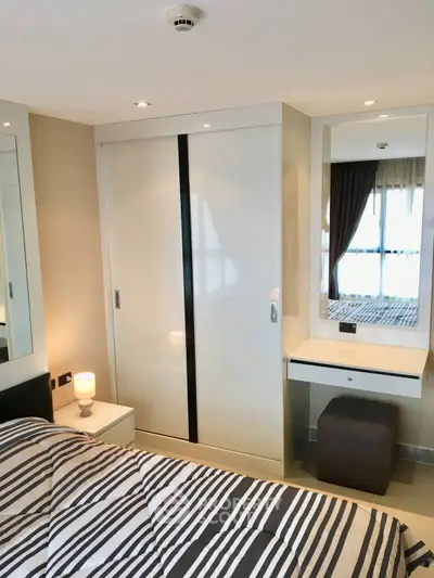 Modern bedroom with sleek wardrobe and cozy lighting in a stylish apartment.