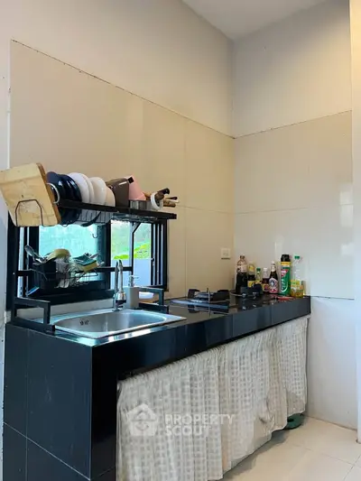 Charming kitchen with modern black counter and ample storage space