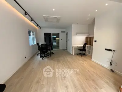 Spacious modern office space with wooden flooring and ample natural light