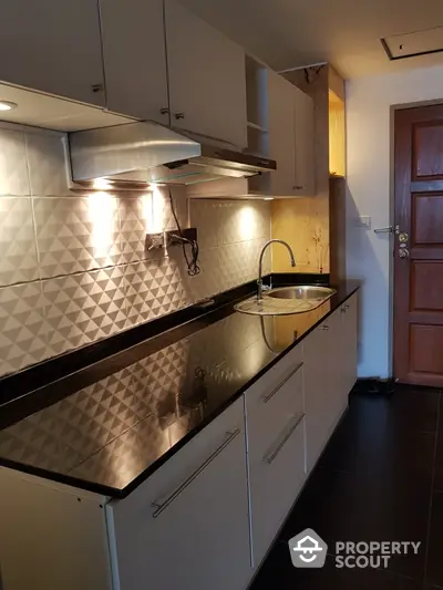 Modern kitchen with sleek black countertops and stylish backsplash