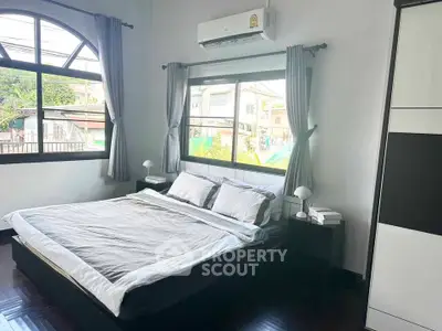 Spacious bedroom with large window and modern furnishings, perfect for comfort and relaxation.