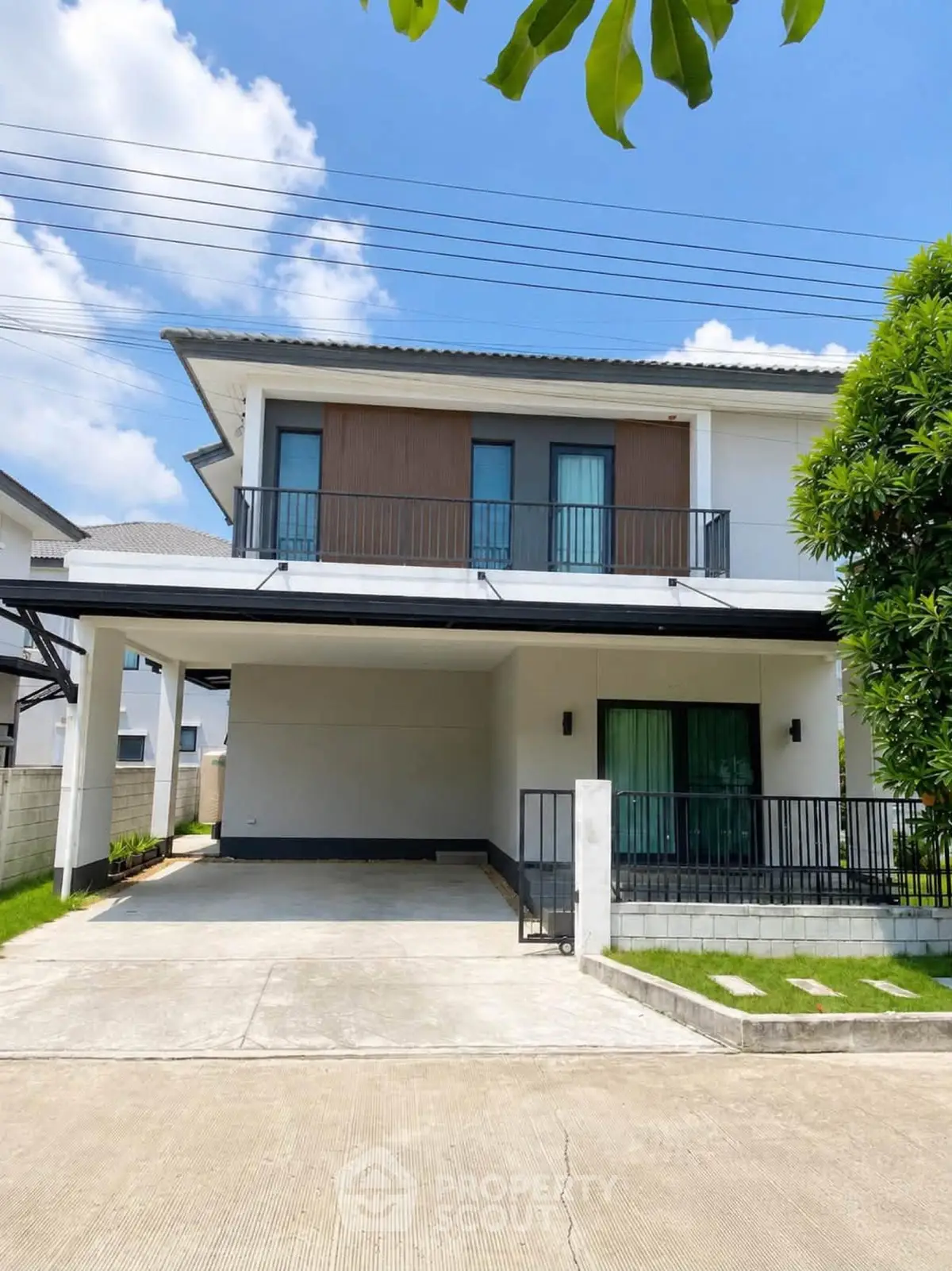 Modern two-story house with spacious driveway and lush greenery, perfect for family living.