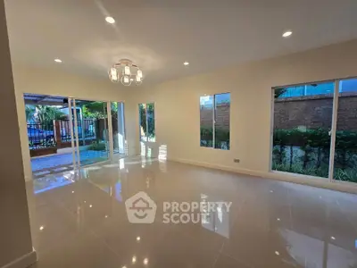 Spacious living room with large windows and garden view, perfect for natural light lovers.