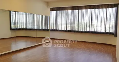Spacious room with large mirrors and panoramic windows, ideal for dance or yoga studio.