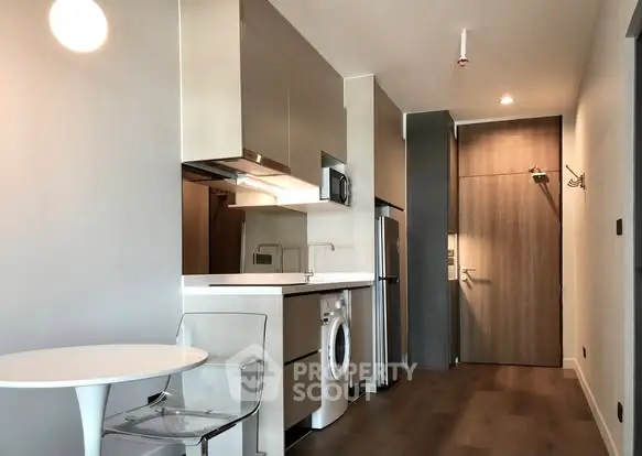 Modern apartment interior with sleek kitchen and washing machine, featuring minimalist design and stylish lighting.