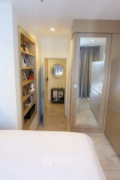 Modern bedroom with built-in shelves and mirrored closet doors