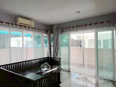 Spacious living room with large windows and elegant curtains