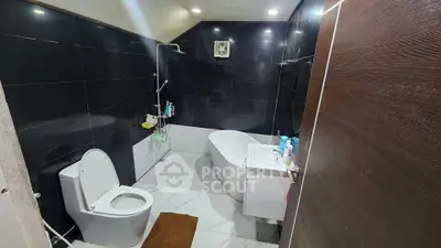 Modern bathroom with sleek black tiles and a stylish bathtub