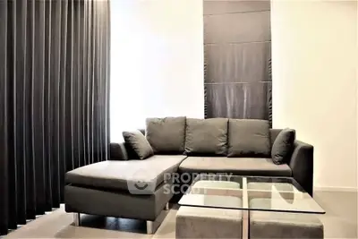 Modern living room with sleek black sofa and glass coffee table, perfect for stylish urban living.