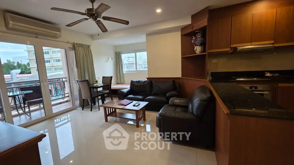 Spacious living room with open kitchen and balcony view in modern apartment
