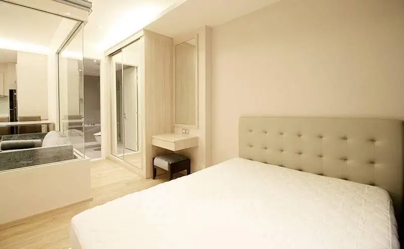 Modern bedroom with elegant design and glass partition in a stylish apartment.