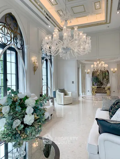Luxurious living room with elegant chandeliers and large windows in a high-end property.