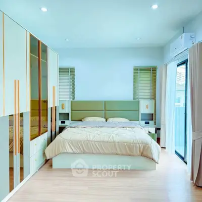 Modern bedroom with stylish built-in wardrobe and large window for natural light.