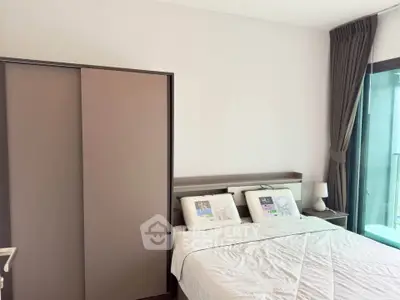 Modern bedroom with sleek wardrobe and balcony view, perfect for urban living.