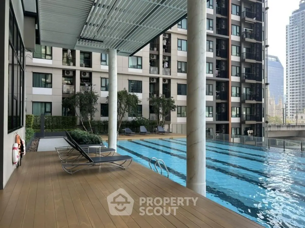 Luxurious apartment complex with poolside relaxation area and city views.