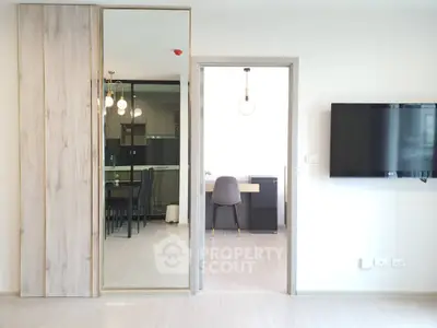 Modern open-plan living space with sleek design and wall-mounted TV