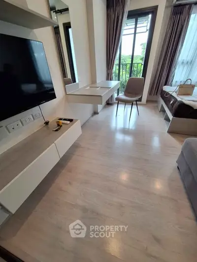 Modern living room with sleek furniture and large windows offering natural light and garden view.