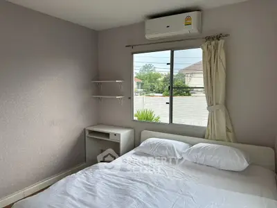Cozy bedroom with air conditioning and natural light, perfect for relaxation and comfort.