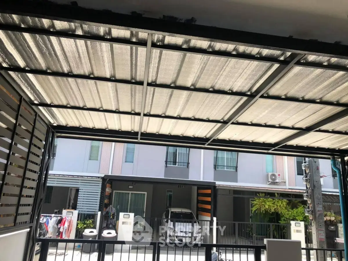 Modern residential building with covered parking and gated entrance