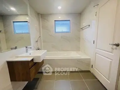Modern bathroom with sleek design and bathtub in a stylish real estate property.