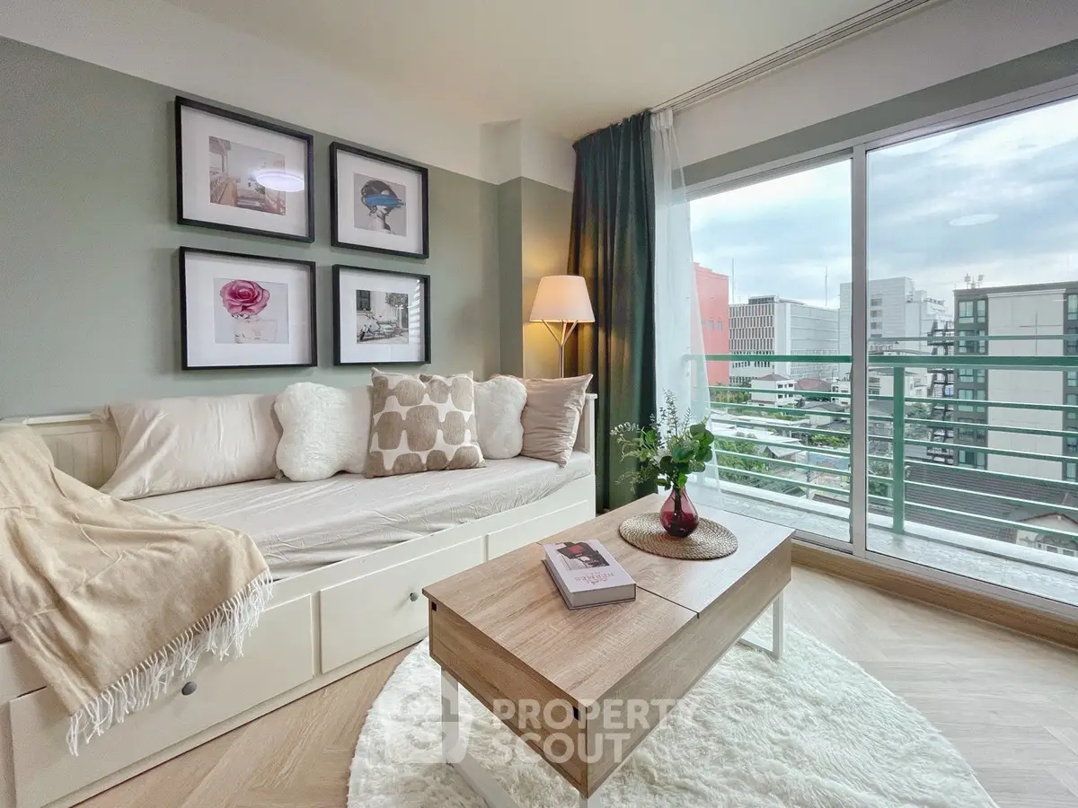 Chic living room with cozy daybed and city view from large window.