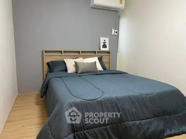 Cozy bedroom with modern decor and air conditioning, perfect for relaxation.