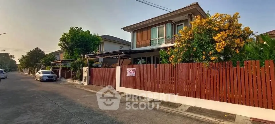 Charming suburban house with lush garden and wooden fence for sale.