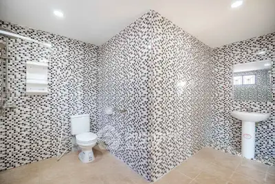 Spacious modern bathroom with mosaic tile walls and sleek fixtures
