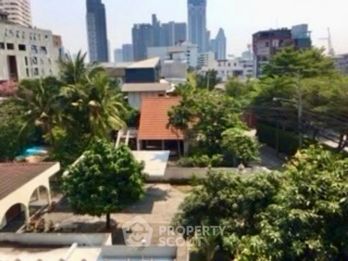 Stunning urban view with lush greenery and city skyline in the background.