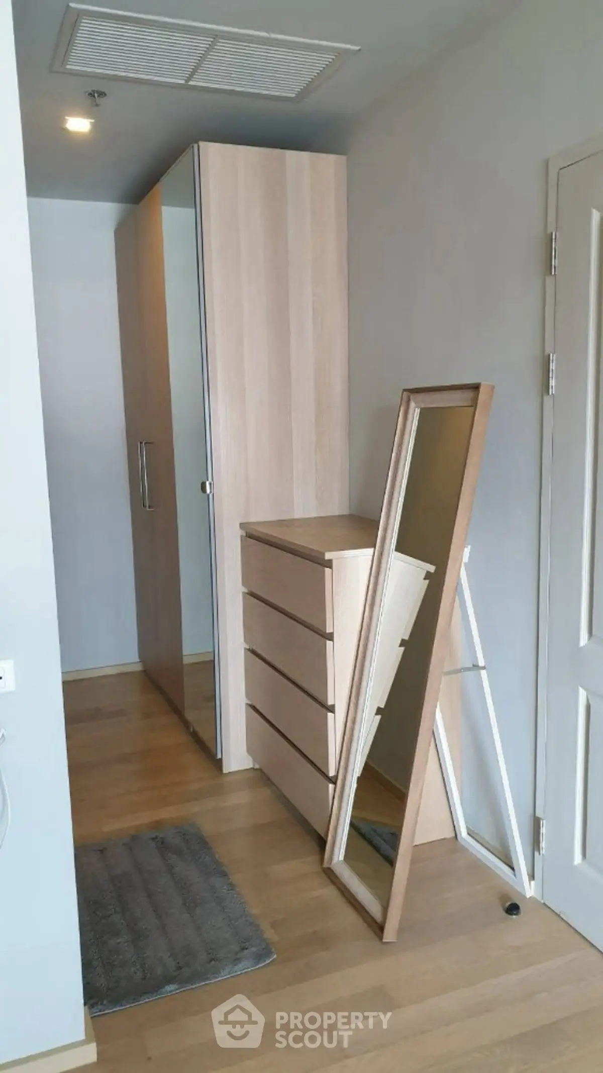 Modern bedroom with sleek wardrobe and full-length mirror