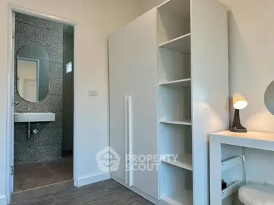 Modern bedroom with sleek white wardrobe and stylish bathroom view