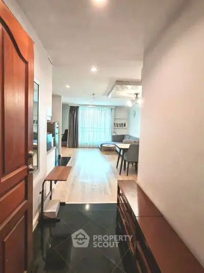 Spacious living room with modern decor and natural light, perfect for relaxation and entertaining.