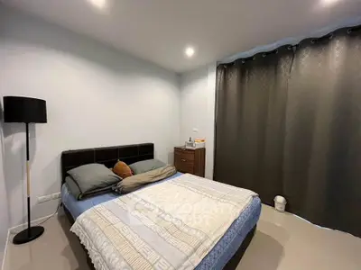 Cozy bedroom with modern decor and ample natural light, perfect for relaxation and comfort.