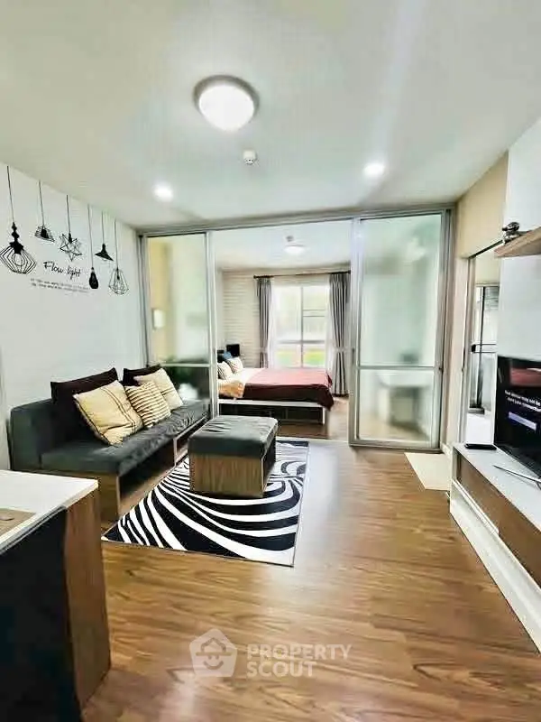 Modern open-plan living room with stylish decor and cozy bedroom view