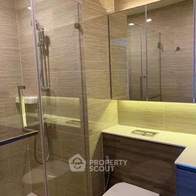 Modern bathroom with glass shower and sleek fixtures in a contemporary home.