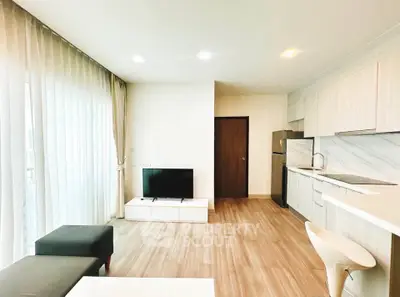 Modern open-layout living room with sleek kitchen and natural light