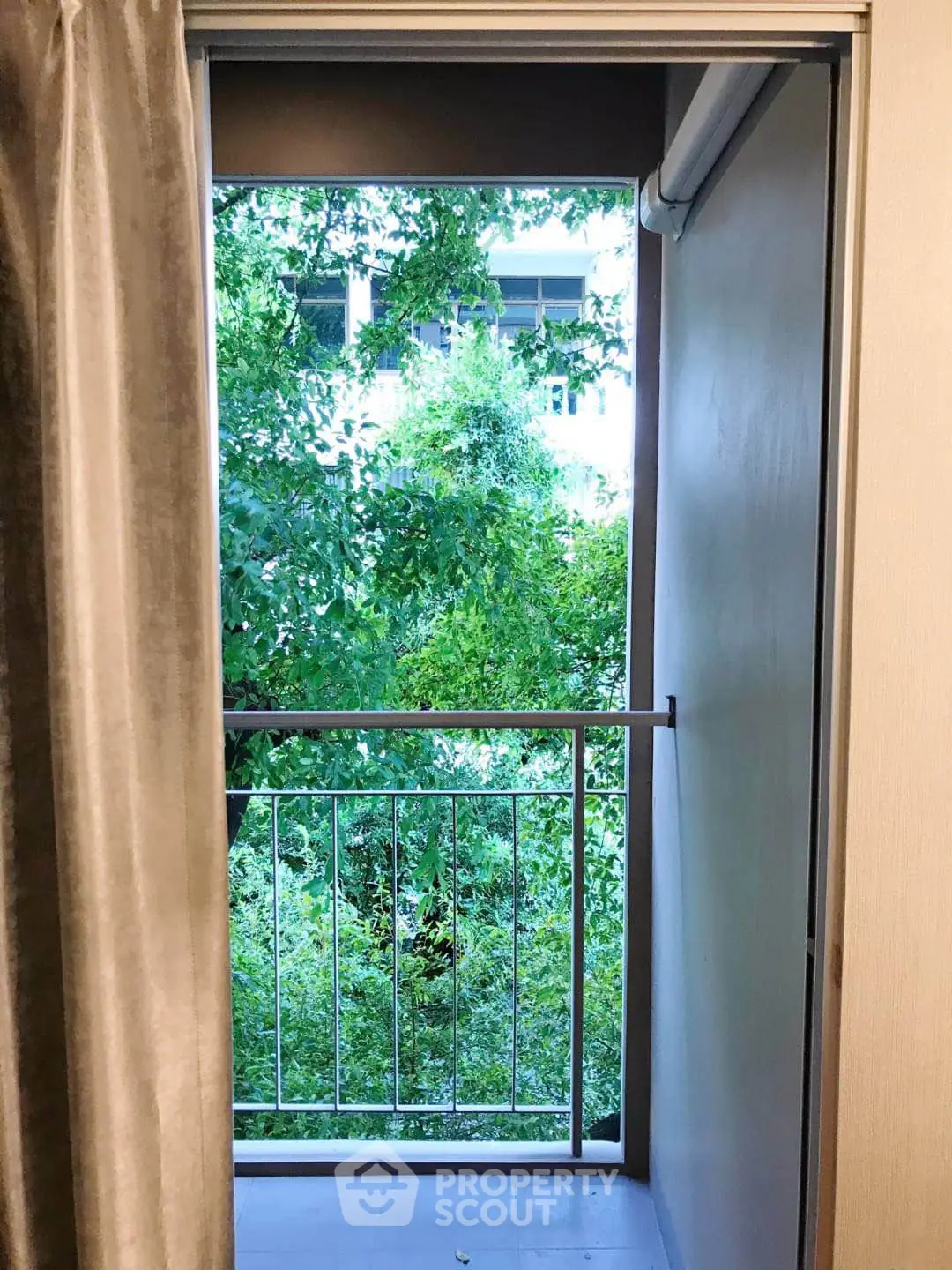 Charming small balcony with lush green view, perfect for relaxation and enjoying nature.