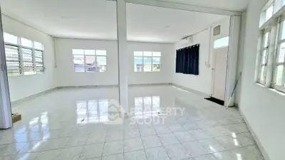 Spacious open-plan living area with large windows and tiled flooring, perfect for customization.