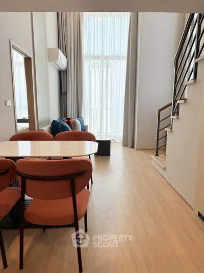 Modern duplex living room with high ceilings and stylish staircase