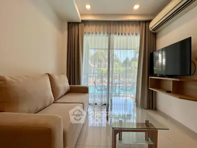 Modern living room with pool view, featuring a cozy sofa and wall-mounted TV, perfect for relaxation.