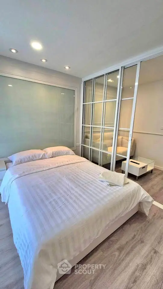 Modern bedroom with glass sliding doors and cozy bedding