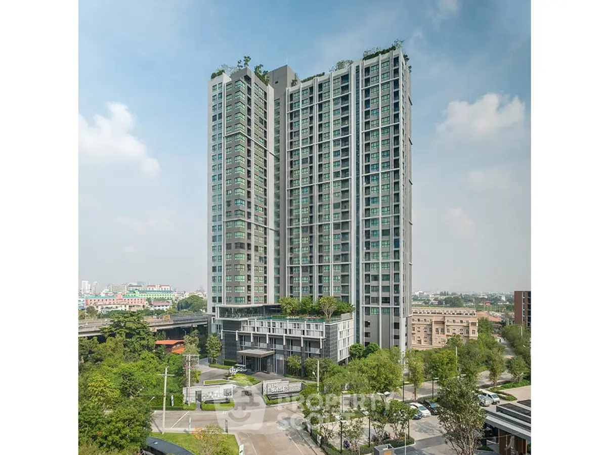 Modern high-rise building with lush greenery and cityscape views, ideal for urban living.