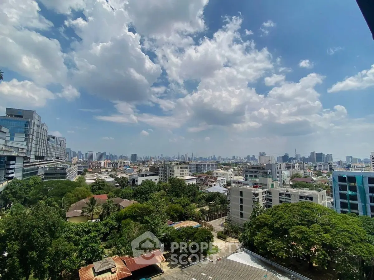 Stunning cityscape view from high-rise building with lush greenery and skyline.