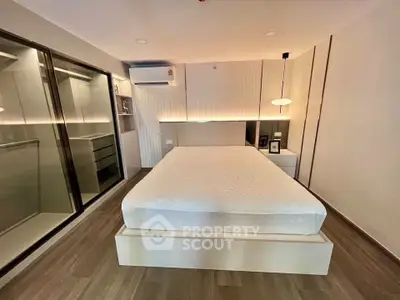 Modern bedroom with sleek design, featuring a comfortable bed and stylish lighting in a contemporary apartment.